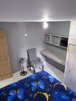 a bedroom with a bed and a chair in a room at Apartamento Super Exclusivo in Medellín
