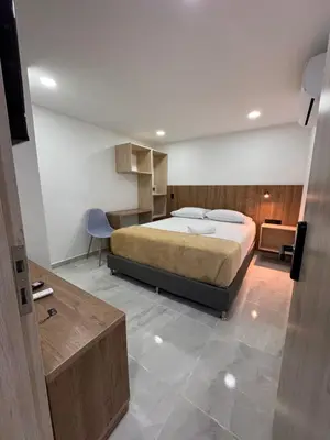 a bedroom with a large bed and a desk at Vida Hostel in Medellín