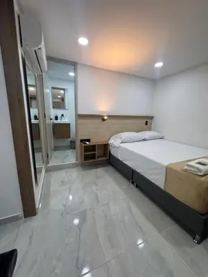 a bedroom with a large bed and a bathroom at Vida Hostel in Medellín