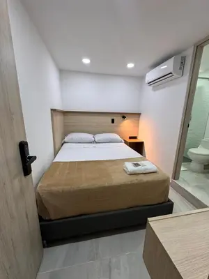 a bedroom with a bed and a bathroom with a toilet at Vida Hostel in Medellín