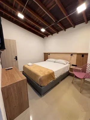 a bedroom with a bed and a desk and a chair at Vida Hostel in Medellín