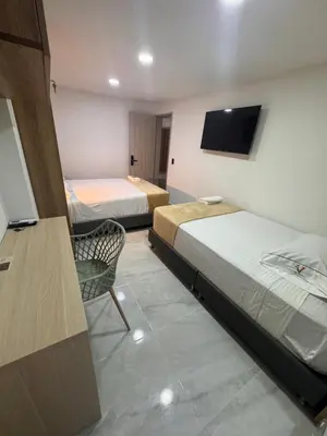 a hotel room with two beds and a television at Vida Hostel in Medellín