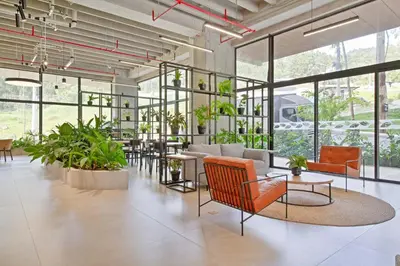 a large room with plants and chairs and tables at Apartamento exclusivo, edificio moderno, gran balcon y linda vista in El Poblado