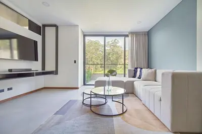 a living room with a white couch and a table at Apartamento exclusivo, edificio moderno, gran balcon y linda vista in El Poblado