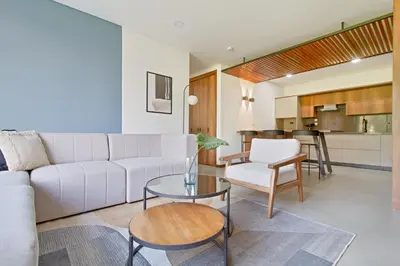 a living room with a white couch and a table at Apartamento exclusivo, edificio moderno, gran balcon y linda vista in El Poblado