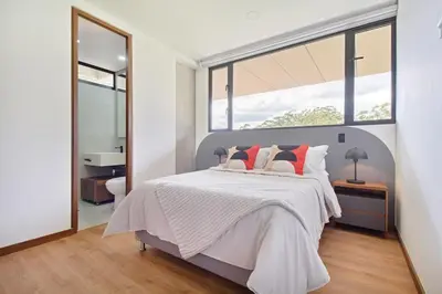 a bedroom with a bed and a large window at Apartamento exclusivo, ideal para familias grandes con una vista sensacional in Medellín