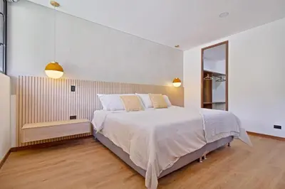 a bedroom with a large white bed and a mirror at Apartamento exclusivo, ideal para familias grandes con una vista sensacional in Medellín
