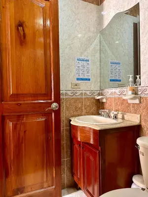 a bathroom with a sink and a toilet and a mirror at Hotel Colonial Aguadas in Aguadas