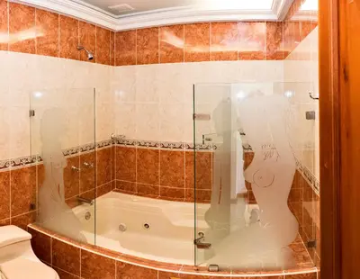 a bathroom with a tub and a glass shower at Hotel Colonial Aguadas in Aguadas
