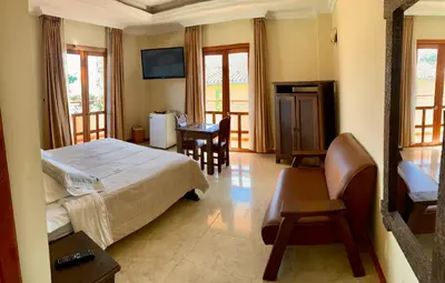 a bedroom with a bed and a desk and a television at Hotel Colonial Aguadas in Aguadas