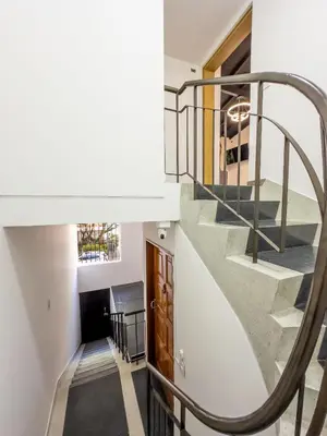 a staircase in a home with white walls and a stair case at Modern Central Apt Laureles Medellin With 3 ACs in Medellín
