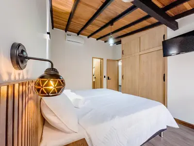 a bedroom with a white bed and a lamp at Modern Central Apt Laureles Medellin With 3 ACs in Medellín
