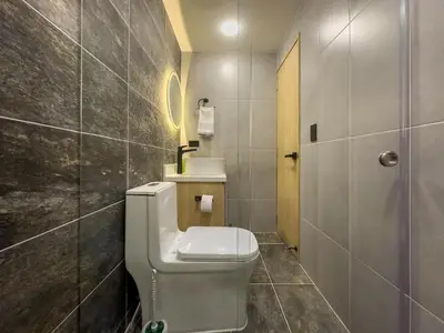 a bathroom with a toilet and a sink at Modern Central Apt Laureles Medellin With 3 ACs in Medellín