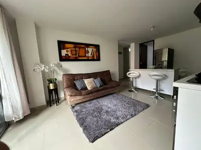a living room with a brown couch and a rug at Apartamento Nuevo Laureles- La 70 in Medellín