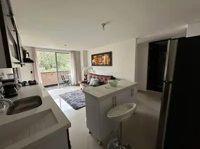 a kitchen and living room with a couch in it at Apartamento Nuevo Laureles- La 70 in Medellín