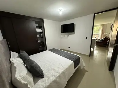 a bedroom with a bed and a television in it at Apartamento Nuevo Laureles- La 70 in Medellín