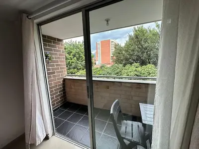 a balcony with a window and a table and chair at Apartamento Nuevo Laureles- La 70 in Medellín