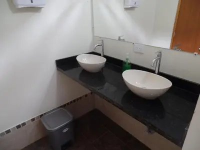 a bathroom with two sinks and a trash can at Finca con jacuzzi a 15min de Guatape in El Peñol