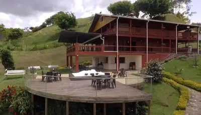 a large building with tables and chairs in front of it at Finca con jacuzzi a 15min de Guatape in El Peñol