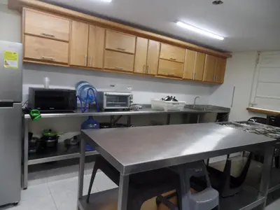 a kitchen with a table and a refrigerator at Finca con jacuzzi a 15min de Guatape in El Peñol