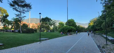 a cobblestone street in a park with people sitting on benches at Casa de las Palmas 1 in Medellín