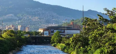 a river next to a city with a mountain at Casa de las Palmas 1 in Medellín
