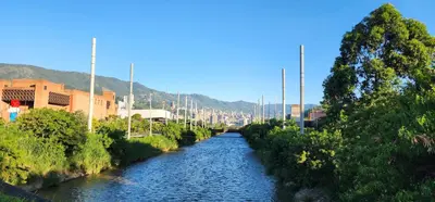 a river in a city with buildings and trees at Casa de las Palmas 1 in Medellín