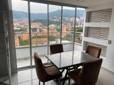 a table and chairs in a room with a large window at Hermoso y nuevo apartamento 2 in Medellín