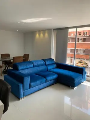a large blue couch in a room with a table at Hermoso y nuevo apartamento 2 in Medellín