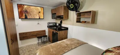 a room with a kitchen with a bed and a sink at Casa de las Palmas 2 in Guayaquil