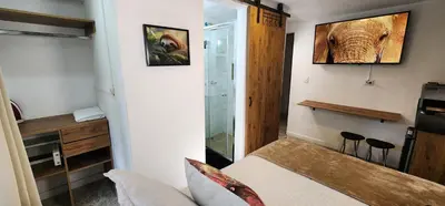 a small bedroom with a bed and a glass shower at Casa de las Palmas 2 in Guayaquil