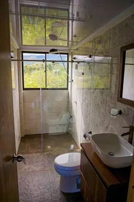 a bathroom with a toilet and a sink at Retro Finca Urrao - Peaceful Avocado Farm Retreat in Urrao
