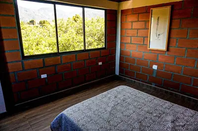 a brick room with a bed and a window at Retro Finca Urrao - Peaceful Avocado Farm Retreat in Urrao