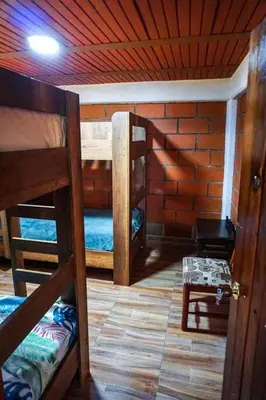 a room with three bunk beds in a room with a wooden ceiling at Retro Finca Urrao - Peaceful Avocado Farm Retreat in Urrao