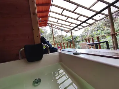 a bathtub in a room with a table and chairs at Finca AVALON Alejandria Antioquia in Alejandría