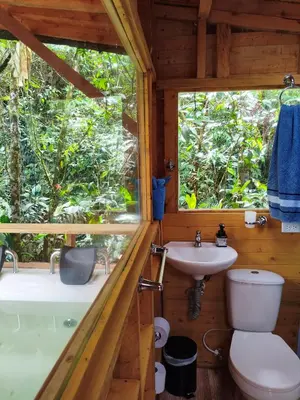 a bathroom with a toilet and a sink and a window at Finca AVALON Alejandria Antioquia in Alejandría