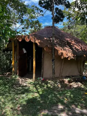 a small house with a rusty roof in the grass at Cabaña en reserva natural in San Rafael