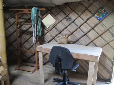a desk in a thatched room with a chair at Cabaña en reserva natural in San Rafael