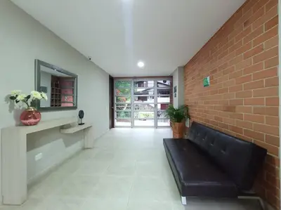 a living room with a couch and a brick wall at Comfortable Apt Envigado 3 Rooms 5 Beds in Envigado