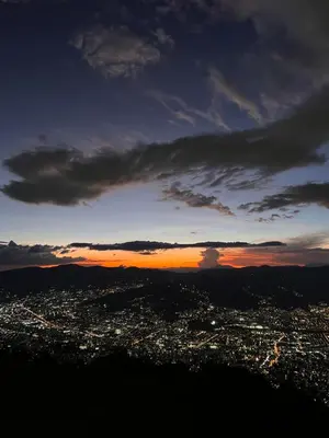 a view of a city at sunset from a mountain at LasNubes EcolodgeNubes Ecolodge in Santa Elena