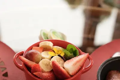 a red bowl filled with fruit and vegetables on a table at LasNubes EcolodgeNubes Ecolodge in Santa Elena