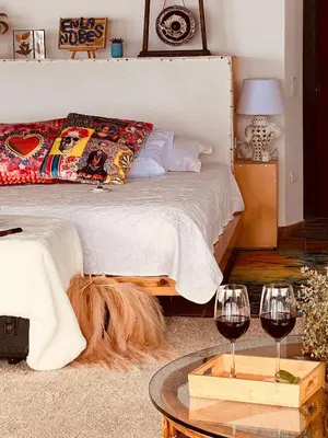 a bedroom with a bed and two glasses of wine at LasNubes EcolodgeNubes Ecolodge in Santa Elena