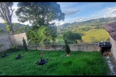 a yard with green grass and a stone wall at Casa de campo in Jericó