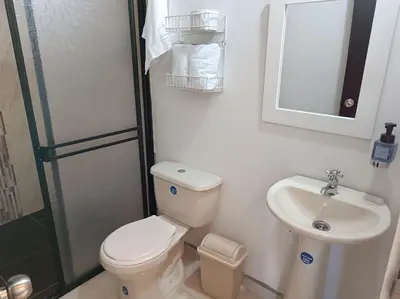 a white bathroom with a toilet and a sink at Casa de campo in Jericó