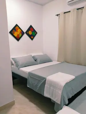 a bedroom with a bed and two paintings on the wall at Apartamento Capri 1 in Puerto Triunfo