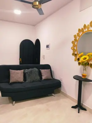 a black couch in a room with a mirror at Apartamento Capri 1 in Puerto Triunfo