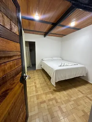 a bedroom with a bed and a wooden door at ECOHOTEL MONTEBELLO Norcasia Caldas in Confines