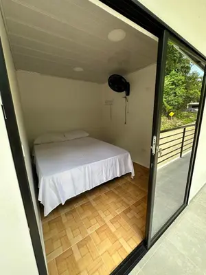 a room with a bed and a sliding glass door at ECOHOTEL MONTEBELLO Norcasia Caldas in Confines
