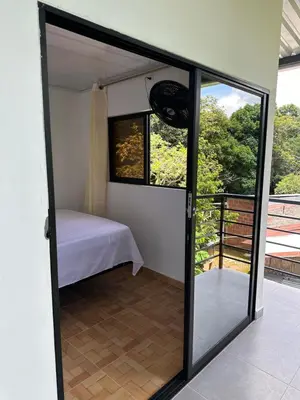 a sliding glass door leading into a bedroom with a bed at ECOHOTEL MONTEBELLO Norcasia Caldas in Confines