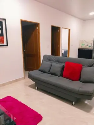 a living room with a gray couch with a red pillow at Apartamento Capri 2 in Puerto Triunfo